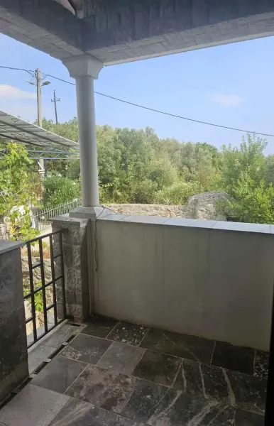 &Uuml;berdachte Terrasse mit Steinboden, S&auml;ule und Blick ins gr&uuml;ne Tal