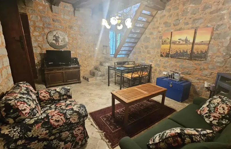 Rustikales Wohnzimmer mit Steinw&auml;nden, Treppe, Sofa und Esstisch