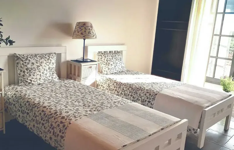 Bedroom with two single beds, natural light and garden view