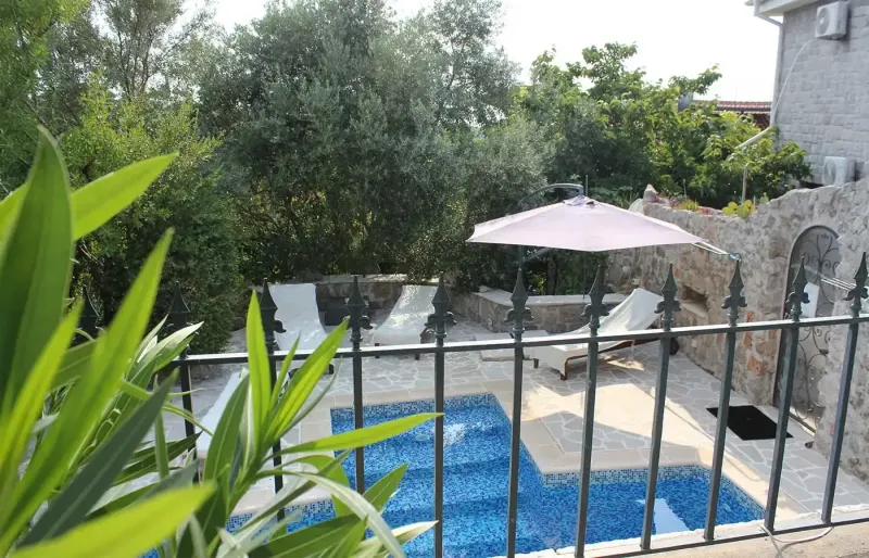 Garden pool area with loungers, natural stone walls and Mediterranean plants