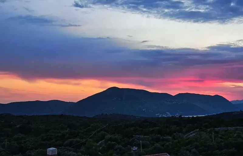 Dramatic evening sky over mountains and sea in vivid colors