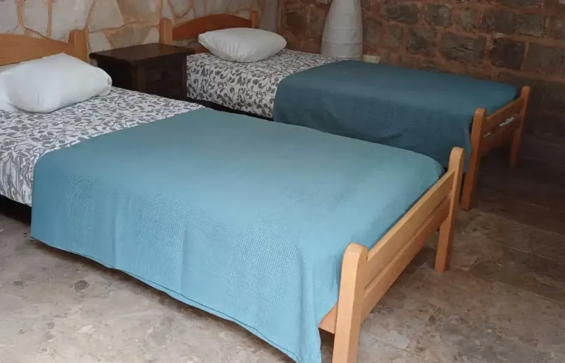 Bedroom with two single beds, wooden frames and blue blankets